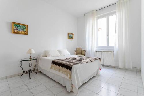 une chambre blanche avec un lit et une fenêtre dans l'établissement appartement 120M2 plage des catalans, à Marseille