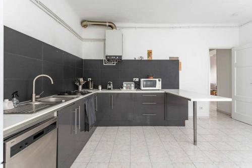 une cuisine avec un évier et un micro-ondes dans l'établissement appartement 120M2 plage des catalans, à Marseille