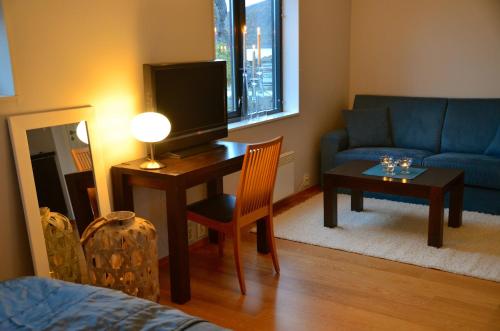 a living room with a desk with a television and a couch at Hamn i Senja in Hamn