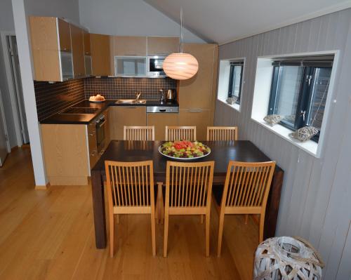 a kitchen with a table and chairs with a bowl of fruit at Hamn i Senja in Hamn