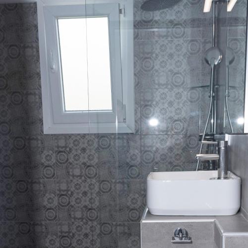 a bathroom with a sink and a window at Eleni's Seaview House in Andros