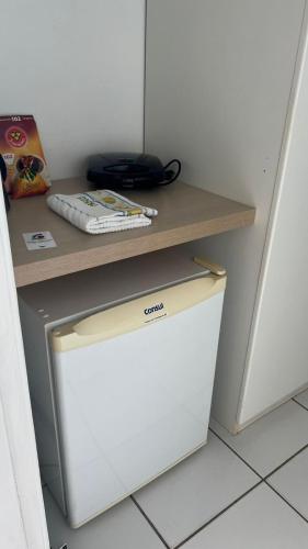 a white refrigerator under a counter with a shelf at Gran Solare Flat Residence - Mandacaru 505 in Barreirinhas