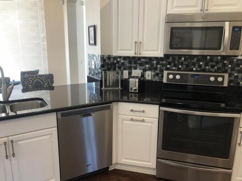 a kitchen with a stainless steel stove and microwave at Private Large Pool Villa Southern Dunes Golf Views Large Pool Deck in Haines City