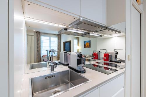 une cuisine avec un évier et un plan de travail dans l'établissement Appartement Cosy au cœur du Triangle d Or avec Climatisation, à Paris