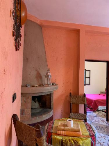 a room with a fireplace and a table and chairs at Auberge Le Mouflon in Ouirgane