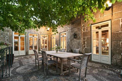 a wooden table and chairs in front of a building at Solar de Vilar Seco in Vilar Seco