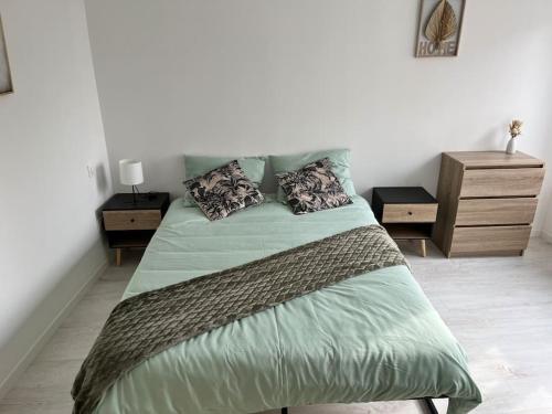 une chambre avec un grand lit avec deux tables de nuit dans l'établissement Maison centre ville Ardres, à Ardres