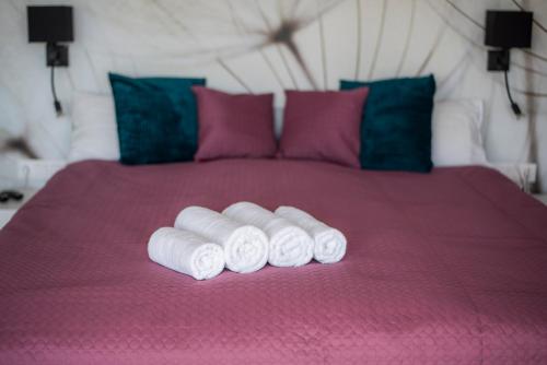 a group of rolled towels on a pink bed at Horizont Apartman in Alsóörs