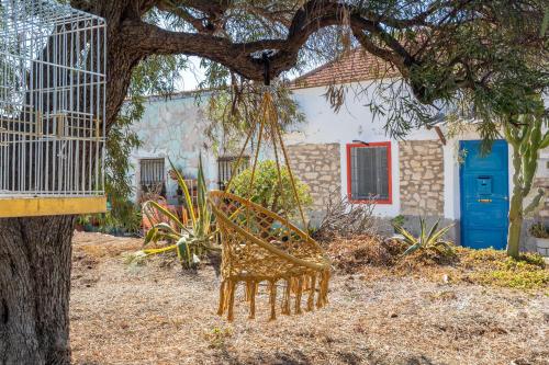a chair hanging from a tree in front of a house at Las Casitas Del Mar in Alicante