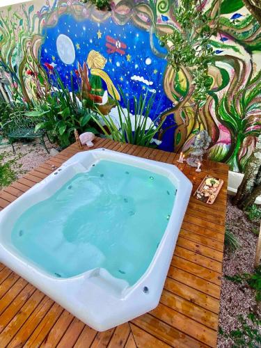 a bath tub sitting on a wooden deck with a mural at Private Cosmic VILLA! 2 Homes, Yoga Room & JACUZZI! in Alto Paraíso de Goiás