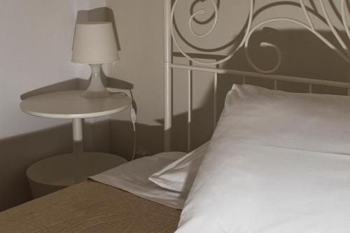 a bedroom with a bed with a lamp and a table at Eleni's Seaview House in Andros