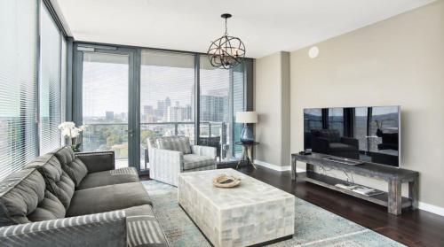 a living room with a couch and a tv at Piedmont Park 3 bdrm with city views in Atlanta