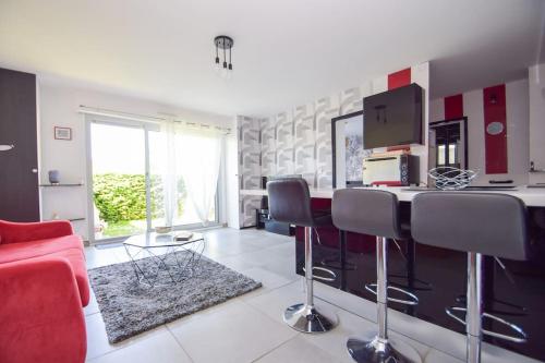 un salon avec un canapé rouge et une table dans l'établissement Appt 4 pers à 400m plage avec jardin, à Dinard