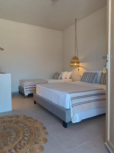 a bedroom with two beds and a rug at Petra Lodge in Finikas