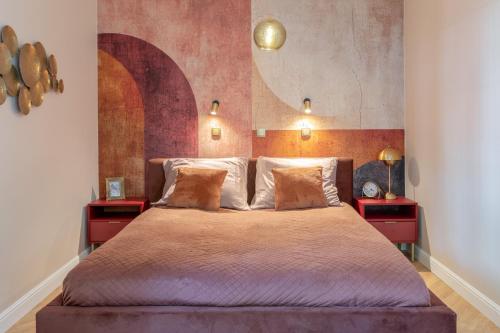 a bedroom with a large bed with two red end tables at Amber Apartament in Gdańsk