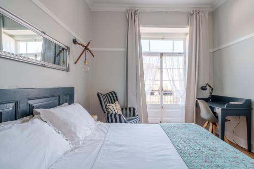 a bedroom with a bed and a desk and a window at Suites do Doutor in Pombal