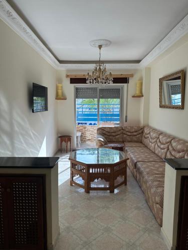 Una sala de estar con un sofá y una mesa de café. en Appartement la cote Martil, en Martil