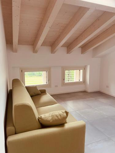 a living room with a couch and two windows at Le Casette Tre in Pacengo di Lazise