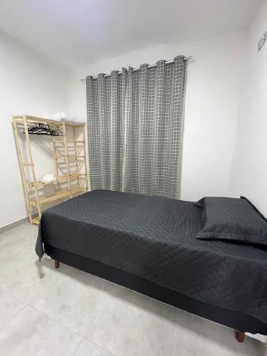 une chambre avec un lit noir et une fenêtre dans l'établissement Executivo Veneza 303, à Ipatinga