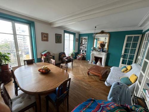 - un salon avec une table et une chambre avec un canapé dans l'établissement Paris style park view 5 bedrooms familly subway 6, à Paris