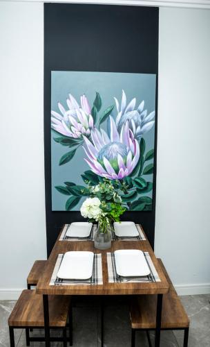 a painting of a table with a vase of flowers at Ellipse Waterfall Luxury Apartments in Midrand