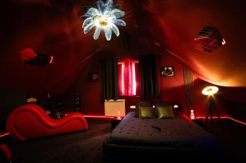 a red room with a bed and a chandelier at Urban Spa 3 nuances de plaisir in Troyes