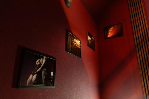 a hallway with red walls with pictures on the wall at Urban Spa 3 nuances de plaisir in Troyes