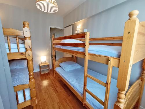 Cette chambre comprend 3 lits superposés avec des draps bleus. dans l'établissement L'appart du Maupas, T3, wifi, parking, à Luchon