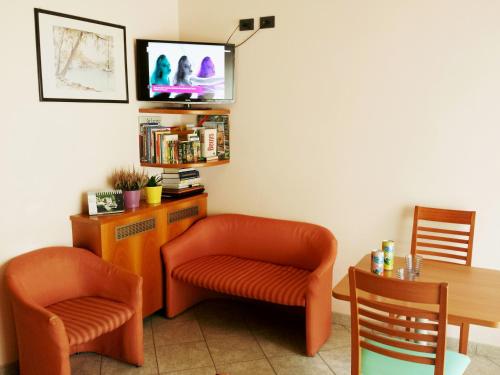 a room with two chairs and a table and a tv at Hotel Eden in Milan