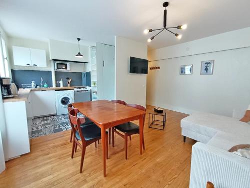Il dispose d'une cuisine et d'un salon avec une table en bois et une salle à manger. dans l'établissement L'appart du Maupas, T3, wifi, parking, à Luchon