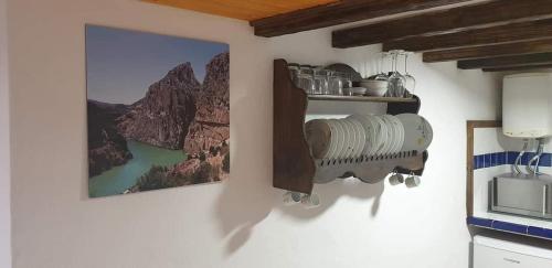 a kitchen with a wall with a fan and a microwave at La guarida delChorro in Málaga