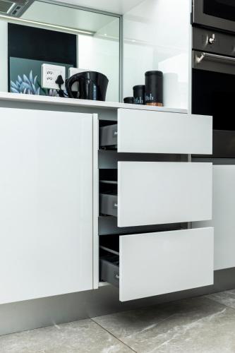 a kitchen with white drawers and cabinets at Ellipse Waterfall Luxury Apartments in Midrand