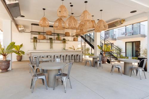 a restaurant with tables and chairs and chandeliers at The Lum Hotel Los Angeles Stadium District in Inglewood