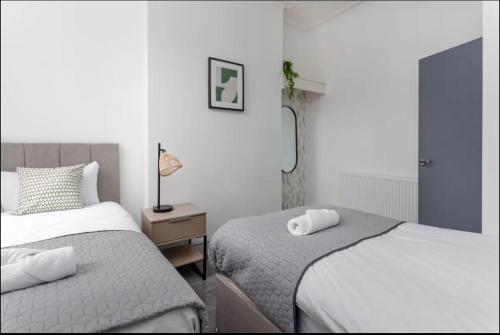 Un dormitorio con dos camas y una mesa con lámpara. en Residency apartments Liverpool, en Liverpool