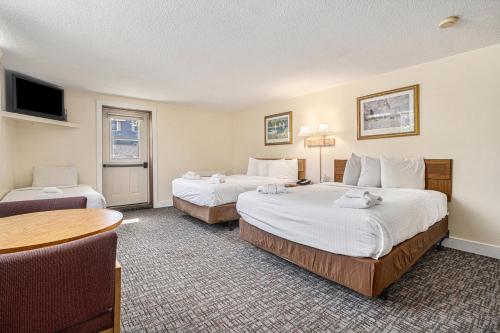 a hotel room with two beds and a table at Ludington Pier House in Ludington