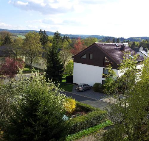 a house with a car parked in a parking lot at Gästehaus Guter Stern in Bad Steben