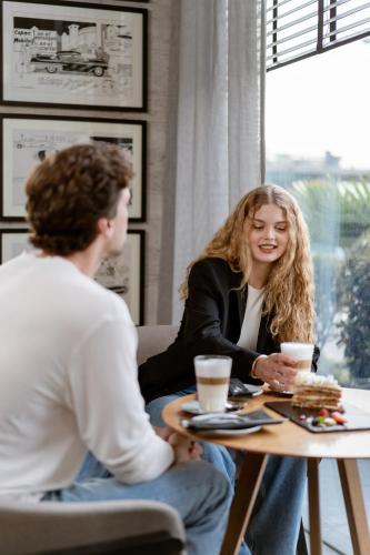 a woman sitting at a table talking to a man at Pullman Vina del Mar San Martin in Viña del Mar