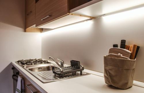 a kitchen counter with a sink and a dish rack at Appartamento Maniero 55 in Domaso