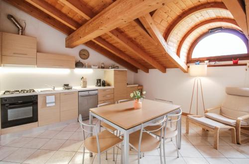 a kitchen and dining room with a table and chairs at Appartamento Maniero 55 in Domaso