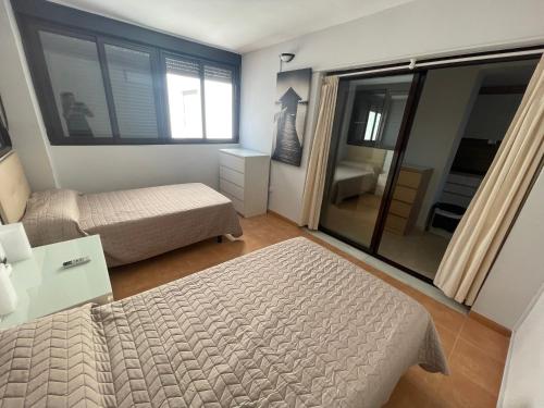 a small bedroom with a bed and a window at Ático con terraza y vistas en Carboneras in Carboneras