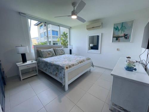 a bedroom with a bed and a window at Amazing beach and golf condo Playa Dorada in Sampiño