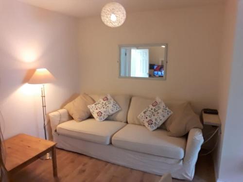 a living room with a couch and a mirror at Cute Flat 600m to the beach private parking in Perranporth