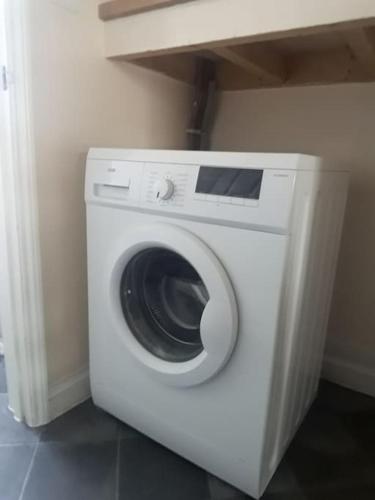 a white washing machine sitting in a room at Cute Flat 600m to the beach private parking in Perranporth