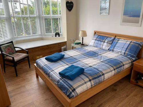 a bedroom with a bed with two blue pillows on it at Cute Flat 600m to the beach private parking in Perranporth