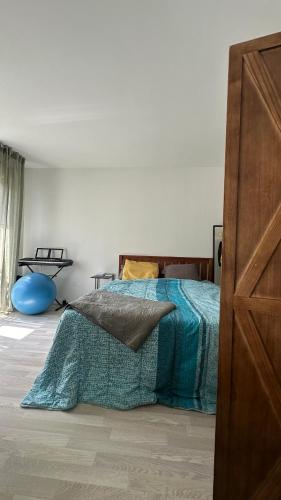 une chambre avec un lit avec une couverture bleue dans l'établissement Grand studio cosy, à Noisy-le-Grand