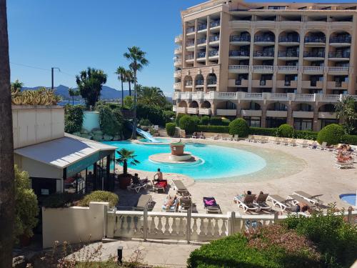 une vue d'une piscine avec un hôtel en arrière-plan dans l'établissement Magnifique T2 Climatisation - Grande Terrasse, Piscine et apercu Mer, à Cannes