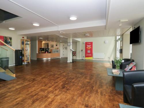 an empty room with a hard wood floor in a building at 1 Eamont Park in Penrith