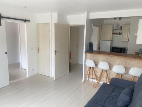 - un salon avec un canapé bleu et des tabourets blancs dans l'établissement Le petit nid de Disney3min, Rer1min, Paris35min, à Chessy