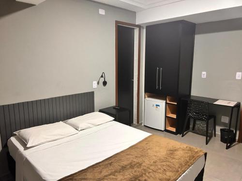 a bedroom with a bed and a desk in it at Terrazas Hotel in Curitiba