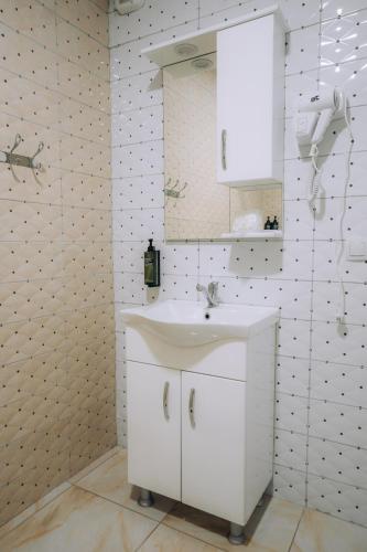 a white bathroom with a sink and a mirror at Tim Apartmani in Ohrid